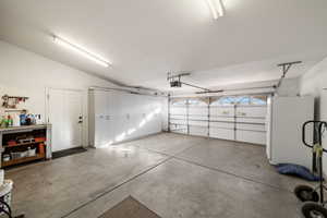 Garage with white fridge and a garage door opener