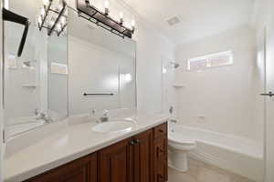 Full bathroom with toilet, crown molding, shower / bathtub combination, and vanity