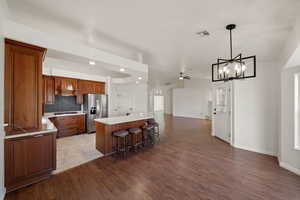 Kitchen featuring premium range hood, a center island, stainless steel refrigerator with ice dispenser, a kitchen breakfast bar, and gas stovetop