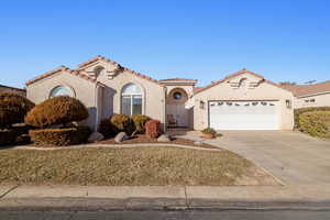 Mediterranean / spanish home with a front lawn and a garage