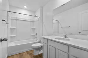 Full bathroom featuring vanity, toilet, shower / washtub combination, and wood-type flooring