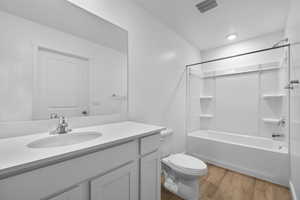 Full bathroom with wood-type flooring, toilet, vanity, and bathing tub / shower combination