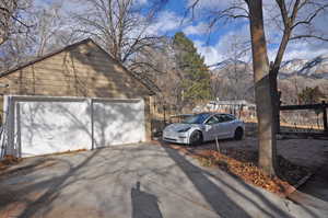 View of side of property featuring a garage, a mountain view, and an outbuilding