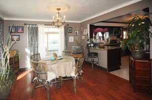 Dining area featuring a textured ceiling, light hardwood / wood-style flooring, and an inviting chandelier