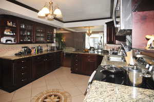 Kitchen featuring sink, an inviting chandelier, hanging light fixtures, and crown molding