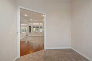 Empty room featuring carpet and crown molding