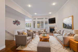 Living room with crown molding and hardwood / wood-style floors. Virtually staged.