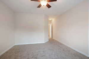 Carpeted empty room with ceiling fan