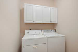 Washroom featuring cabinets and independent washer and dryer