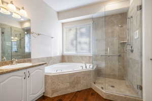 Bathroom featuring independent shower and bath, hardwood / wood-style flooring, and vanity