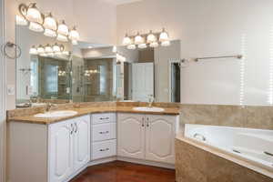 Bathroom featuring shower with separate bathtub, hardwood / wood-style flooring, and vanity