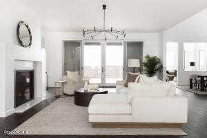 Living room with dark hardwood / wood-style floors and a notable chandelier