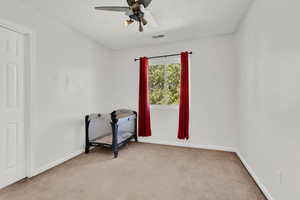 Carpeted empty room featuring ceiling fan