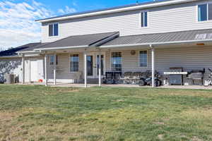 Back of house with a patio area, a yard, and central AC