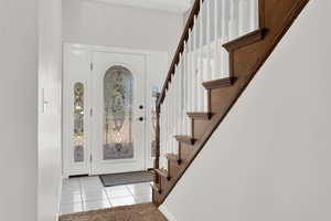 Tiled foyer entrance featuring a towering ceiling