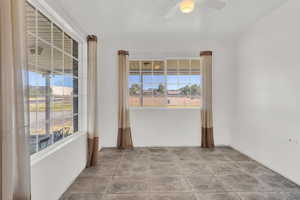 Empty room with ceiling fan and a wealth of natural light