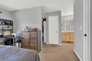 Carpeted bedroom featuring ensuite bath