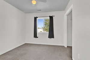 Carpeted spare room with ceiling fan