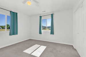 Spare room featuring light colored carpet and ceiling fan