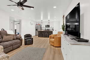 Living room with light wood-type flooring and ceiling fan