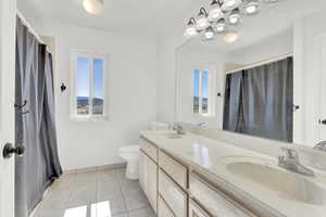 Bathroom with tile patterned floors, vanity, and toilet