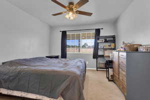 Carpeted bedroom featuring ceiling fan