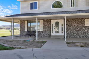 Doorway to property with covered porch and a mountain view