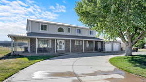 View of front of property featuring a front yard, a porch, and a garage