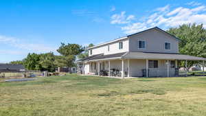 Back of property with a yard and a patio