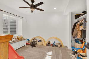 Game room with ceiling fan and carpet flooring