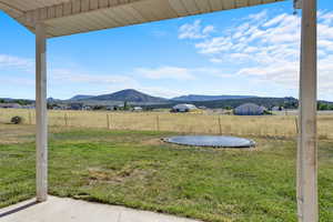 View of yard featuring a mountain view, a trampoline, and a rural view