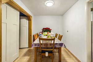 Dining room featuring a textured ceiling and light tile patterned flooring