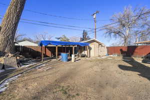 Rear view of property featuring a storage unit