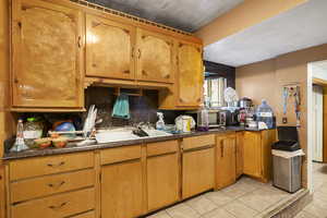 Kitchen featuring sink, tasteful backsplash, and light tile patterned floors