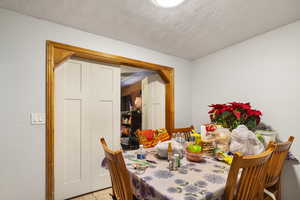 Dining space with light tile patterned floors and a textured ceiling