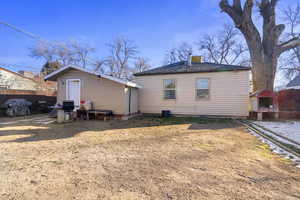 Back of property featuring an outdoor structure