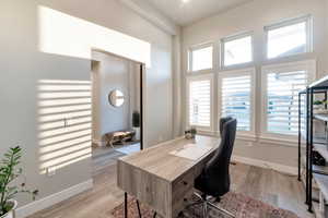 Office area featuring light hardwood / wood-style flooring and vaulted ceiling