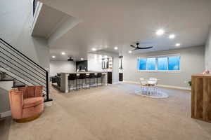 Living room featuring ceiling fan and light carpet