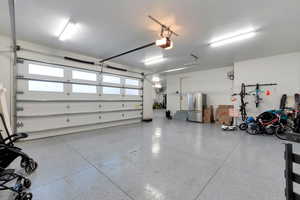 Garage with a garage door opener and stainless steel fridge