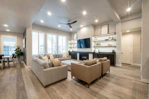 Living room featuring ceiling fan, light hardwood / wood-style flooring, and a fireplace