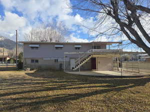 Rear view of property with a patio area and a lawn