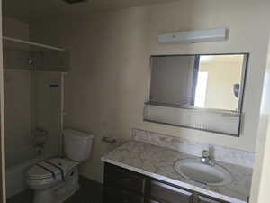 Full bathroom featuring vanity, toilet, and tiled shower / bath combo