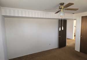 Spare room featuring ceiling fan and carpet