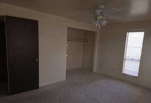 Unfurnished bedroom with a closet, ceiling fan, and carpet flooring