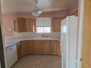 Kitchen featuring sink, ceiling fan, and white appliances