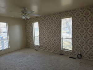 Empty room featuring carpet floors and ceiling fan