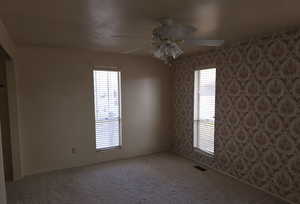 Empty room with ceiling fan and carpet flooring