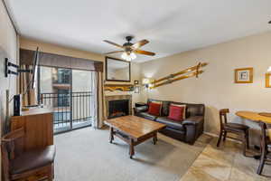 Living room with ceiling fan and a premium fireplace