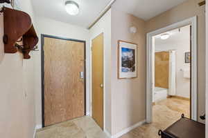 Corridor featuring light tile patterned flooring