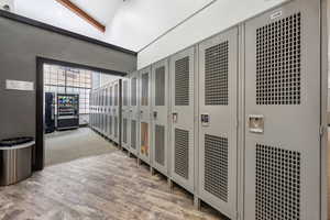 Corridor featuring wood-type flooring and lofted ceiling with beams